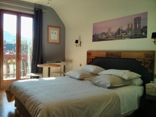 a bedroom with a large bed with a large window at Marcia Donatti - A l'Ombre des Coteaux Sao Paulo in Kaysersberg