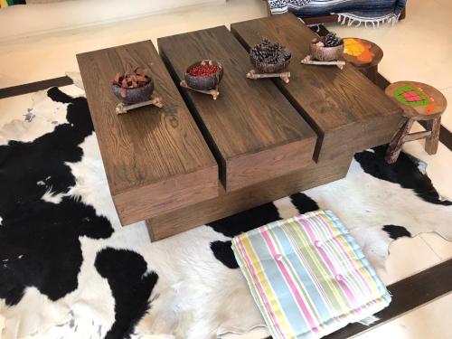 a wooden coffee table with three bowls of food on it at Mexican Beachfront Condo in Khao Tao