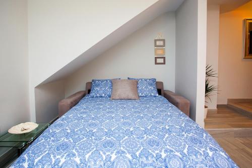 a bed with a blue comforter in a room at Apartamento Vadim in Ardales