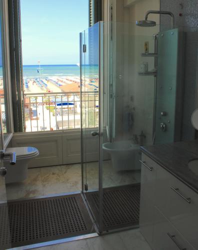 a bathroom with a shower and a view of the beach at Super attico sul mare in Lido di Camaiore