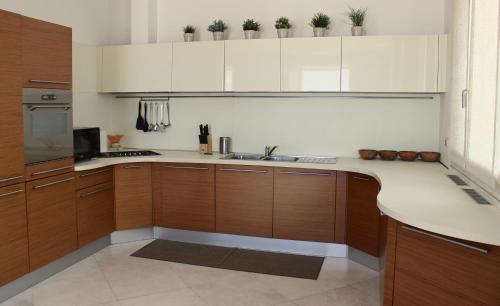 a kitchen with wooden cabinets and a counter top at Super attico sul mare in Lido di Camaiore