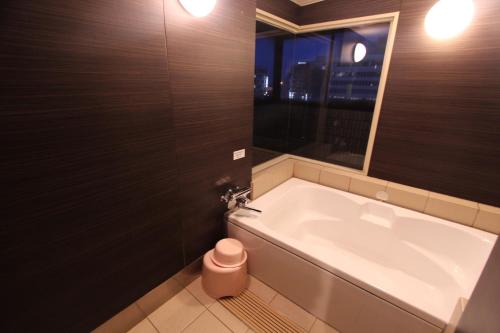 a bath tub in a bathroom with a window at Lala Fleur (Adult Only) in Osaka