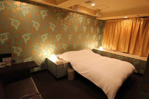 a bedroom with a bed and floral wallpaper at Lala Fleur (Adult Only) in Osaka