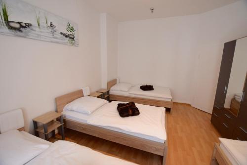 ein Zimmer mit 2 Betten und einer Handtasche darauf in der Unterkunft Apartment Ostendplatz in Stuttgart