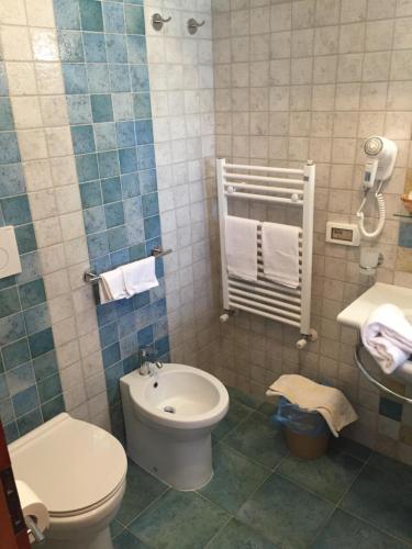 y baño con aseo y lavamanos. en Albergo Villa Mario en Isquia