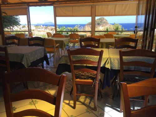 a restaurant with tables and chairs and a view of the ocean at Albergo Villa Mario in Ischia