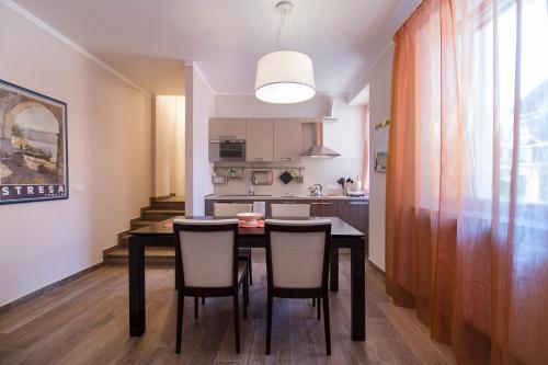 a kitchen with a dining room table and chairs at Apartments La Lombarda Centro Storico Stresa in Stresa