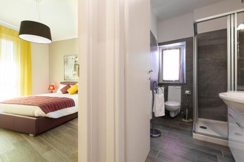 a bedroom with a bed and a bathroom with a sink at Apartments La Lombarda Centro Storico Stresa in Stresa