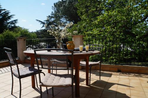 a wooden table and chairs on a patio at Lo Rastelié in Suze-la-Rousse