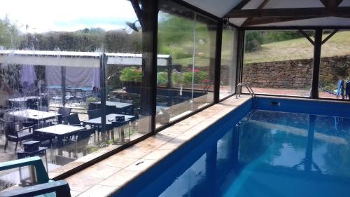 - une piscine avec vue sur une terrasse dotée de tables et de chaises dans l'établissement Le D'Tour Gourmand, à Toulouse-le-Château