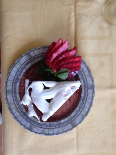 a dessert on a plate with strawberries on a table at Quinta da Cerdeira in Seia