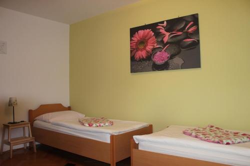 a room with two beds and a picture on the wall at PONI NAKLO - Sobe Marinšek in Naklo