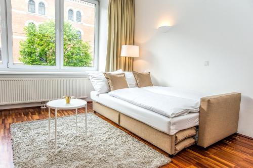 ウィーンにあるBeautiful apartment in Vienna's heartのベッドルーム1室(ベッド1台、テーブル、窓付)
