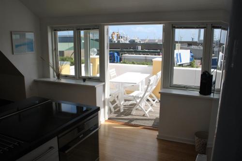 a kitchen with a balcony with a table and chairs at Østre Strandvej 49 in Skagen