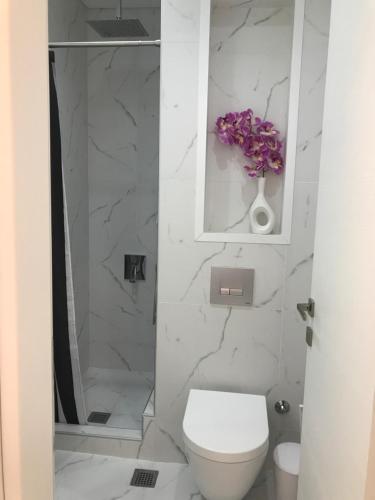 a white bathroom with a toilet and a shower at Laura City Egnatia in Thessaloniki