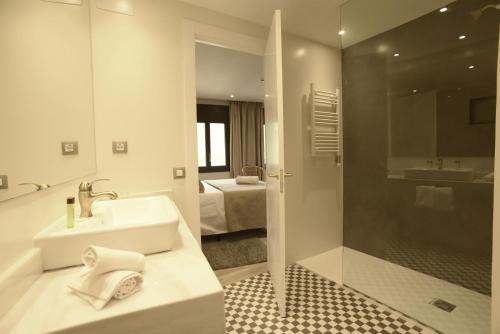 een witte badkamer met een wastafel en een douche bij Casa Moma 1948 in Martinet