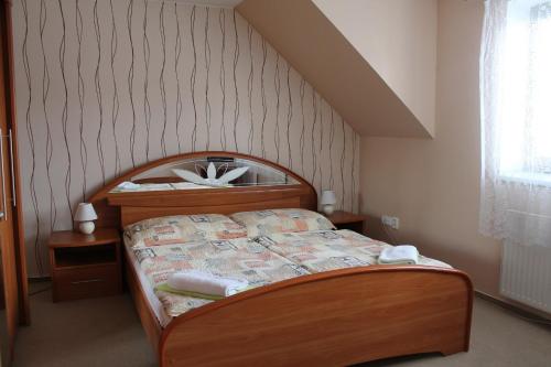 a bedroom with a wooden bed in a room at Penzion U Růže in Sezimovo Ústí