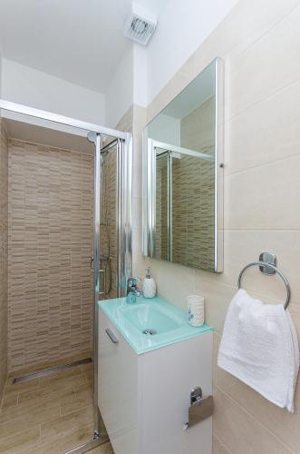 a bathroom with a sink and a mirror at Apartments Keli in Kastel Stari