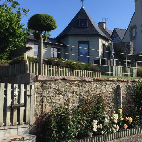 a house with a fence and flowers on a wall at Studio de Charme "Le Coquillage " Jacuzzi privatif in Pléneuf-Val-André