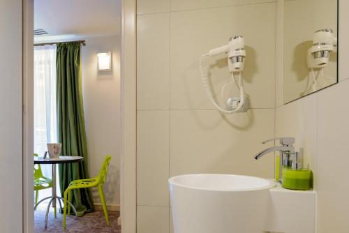 Un baño con lavabo y una silla amarilla en Blumenhaus Sibiu, en Sibiu