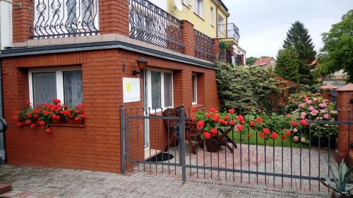 a house with a fence with flowers on it at Villa Selavi in Kołobrzeg