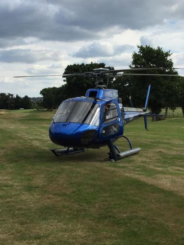 a blue helicopter is parked in a field at Studio de Charme "Le Coquillage " Jacuzzi privatif in Pléneuf-Val-André