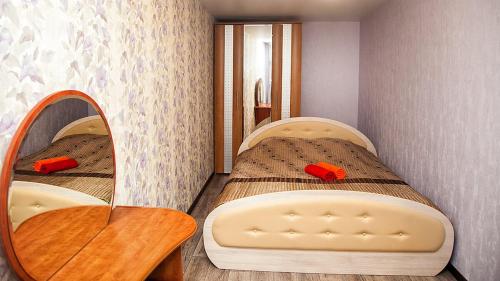 ケメロヴォにあるАпартаменты "Люкс" 50 Лет Октября 21аの小さなベッドルーム(ベッド2台、鏡付)