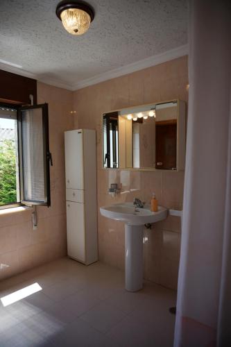 a bathroom with a sink and a mirror and a refrigerator at Casa Maricuelo in Castropol