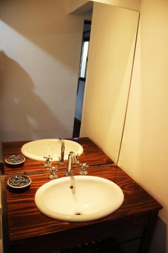 a bathroom with two sinks on a wooden counter at Cabañas El Arcano in Capilla del Monte