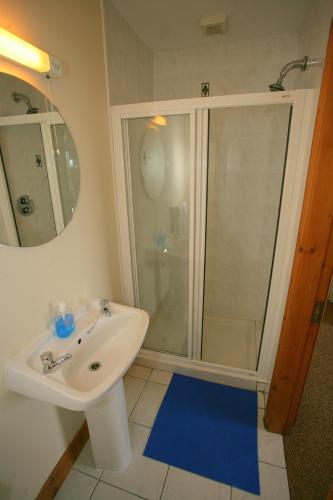 a bathroom with a white sink and a shower at Cottage Heights B&B in Castletownbere