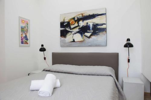 1 dormitorio con 1 cama con 2 lámparas y 1 pintura en La Casa del Gallerista, en Manarola