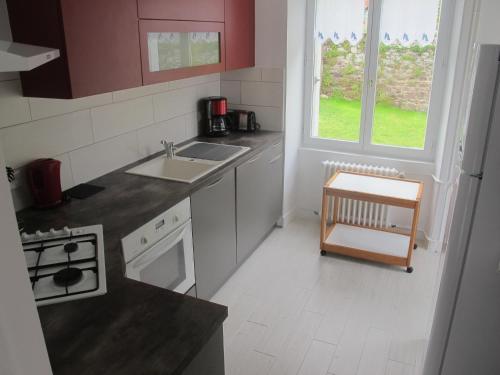 a small kitchen with a sink and a stove at Au Clair de la Dune in Frehel