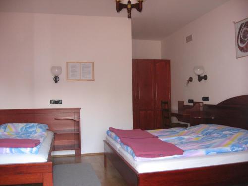 A bed or beds in a room at Pannon Panzió Restaurant
