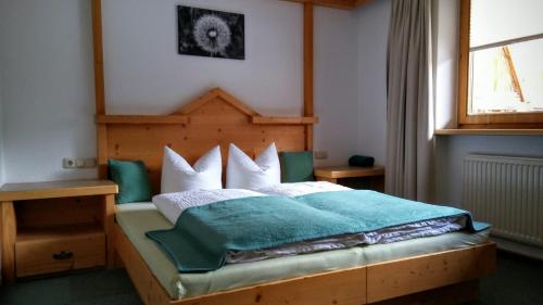 een slaapkamer met een bed met een houten hoofdeinde bij Almhof in Sölden