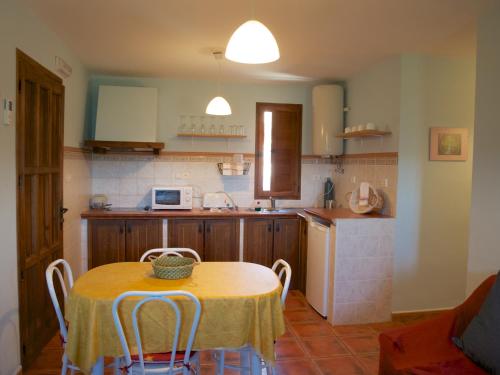 eine Küche mit einem Tisch und Stühlen sowie einem Tisch und einer Küche in der Unterkunft El Corrillo in Trevejo