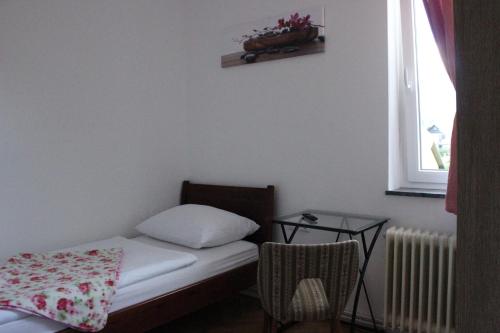 a small room with a bed and a window at PONI NAKLO - Sobe Marinšek in Naklo