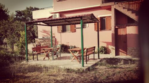 a picnic shelter with a table and chairs in front of a building at Vassilis Studios in Anaxos