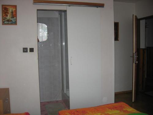 a shower with a glass door in a room at Penzión Závada in Nová Lesná