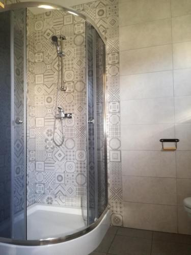 a bathroom with a shower and a bath tub at Domki Letniskowe Gris in Grzybowo