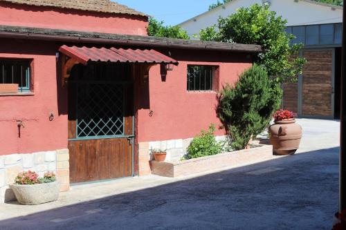 a red building with a wooden door and a window at B&B Colle Cucchiara in Cassino