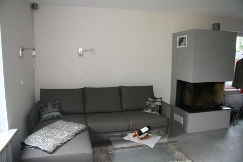 ein Wohnzimmer mit einem Sofa und einem TV in der Unterkunft Ferienwohnung Kiel-Russee in Kiel