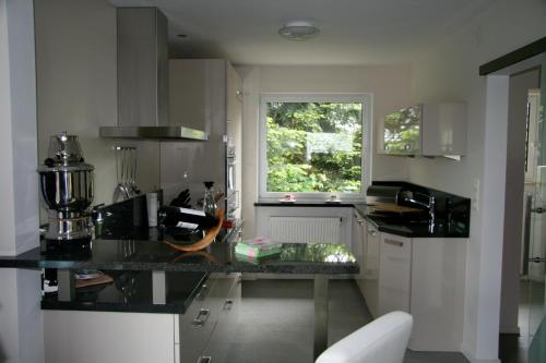 cocina con encimera negra y ventana en Ferienwohnung Kiel-Russee en Kiel