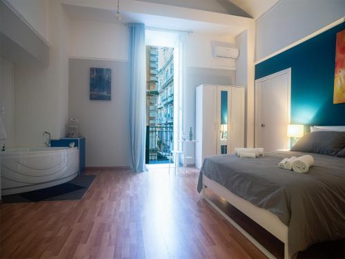 ein Schlafzimmer mit einem großen Bett und einer Badewanne in der Unterkunft Madà B&B in Neapel