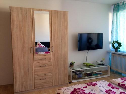 a large wooden cabinet in a bedroom with a tv at Klein und fein in Oberstaufen