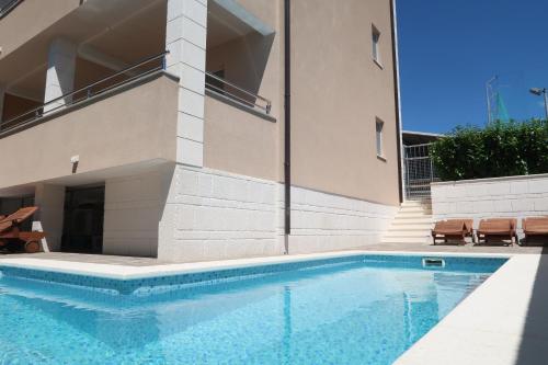 a swimming pool in front of a building at Villa Sunshine in Trogir