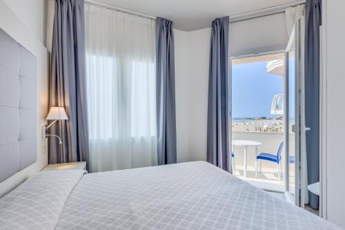 1 dormitorio con cama y vistas al océano en Hotel Garni' Serena, en Caorle