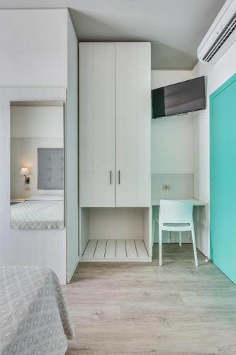 a bedroom with a bed and a desk and a mirror at Hotel Garni' Serena in Caorle