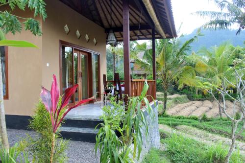 a house with a bed in the middle of a garden at Maha Neka Villa in Sidemen