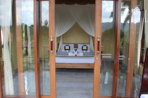a dog laying on a bed in a room at Maha Neka Villa in Sidemen