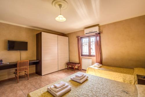 a bedroom with two beds and a desk and a window at Villa Gengi in Ardea